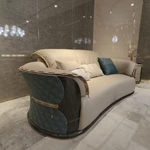 Cream Curved Leather Sofa with Dark Green Fan-Stitched Panels and Laced Edge Details